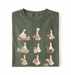 Flat lay of a Cute goose baker shirt with sourdough bread and cottagecore baking artwork on green tee on a white background 
