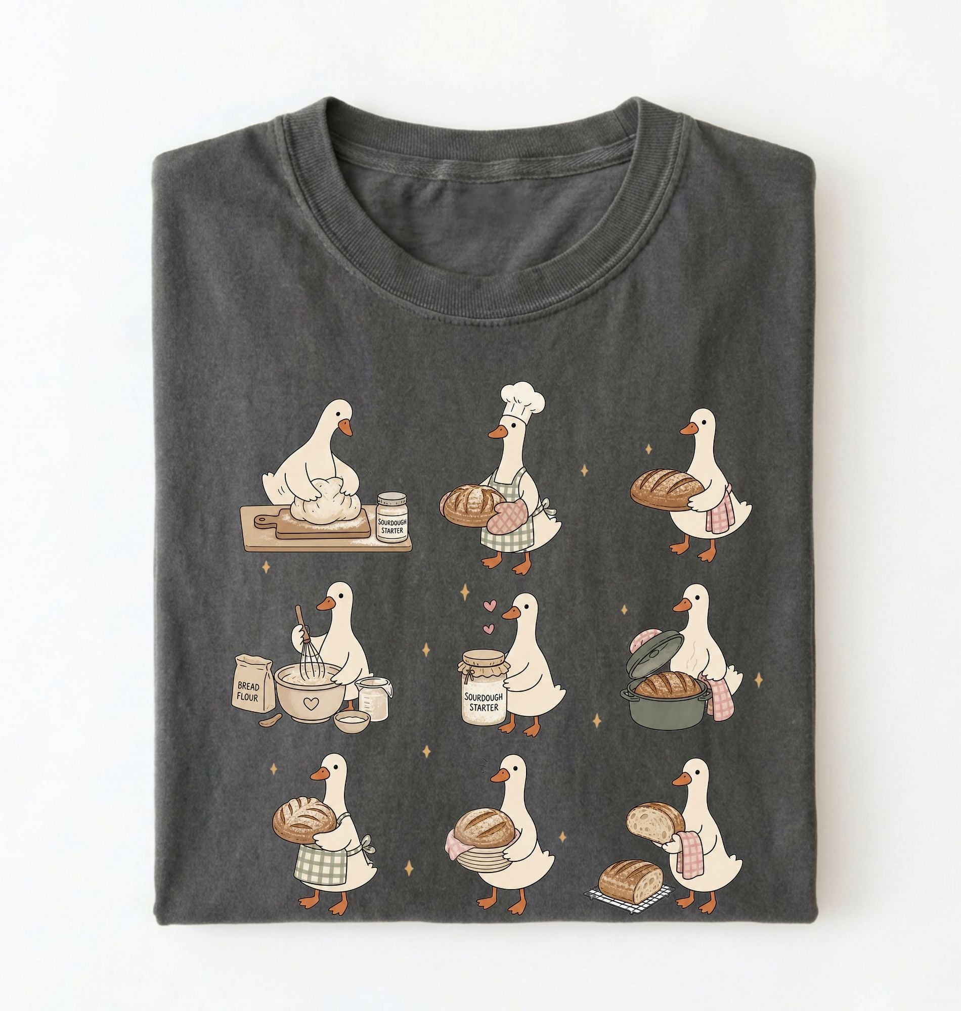 Flat lay of a Cute goose baker shirt with sourdough bread and cottagecore baking artwork on pepper tee on a white background 