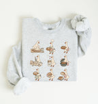 A light heather gray long-sleeve sweatshirt with a graphic print of nine cartoon geese in various baking and bread-related poses, styled flat on a light cream background.