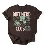 Flat lay of an espresso t-shirt featuring plant illustrations and bold text reading “Dirt Nerd Club.” on a white background