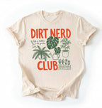 Flat lay of a natural t-shirt featuring plant illustrations and bold text reading “Dirt Nerd Club.” on a white background 