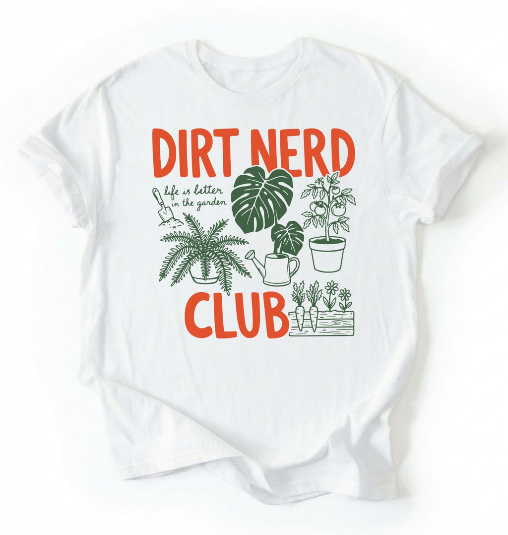 Flat lay of a white t-shirt featuring plant illustrations and bold text reading “Dirt Nerd Club.” on a white background