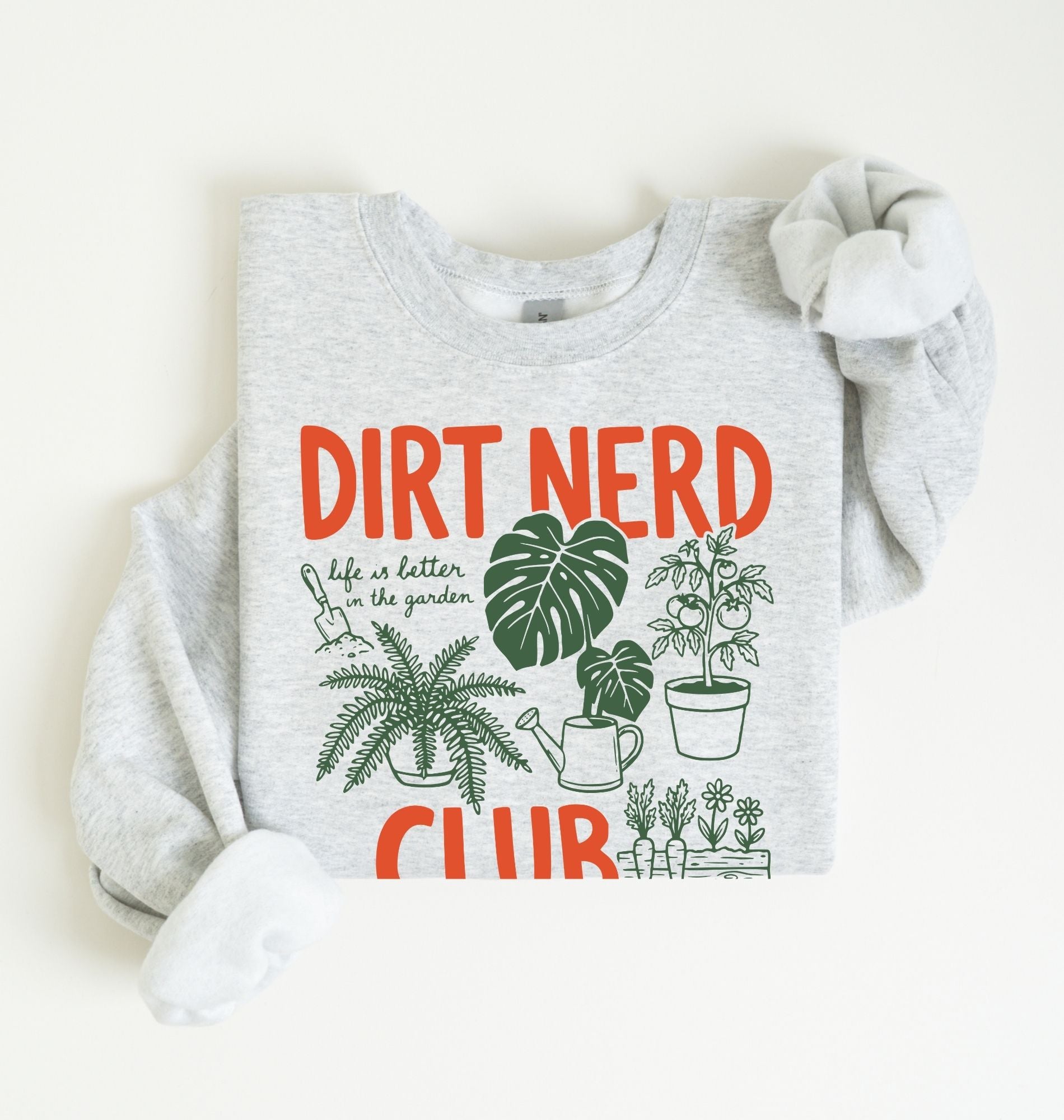 Flat lay of an ash Dirt nerd club sweatshirt with plant illustrations perfect gift for gardeners plant lovers and nature enthusiasts on a white background 