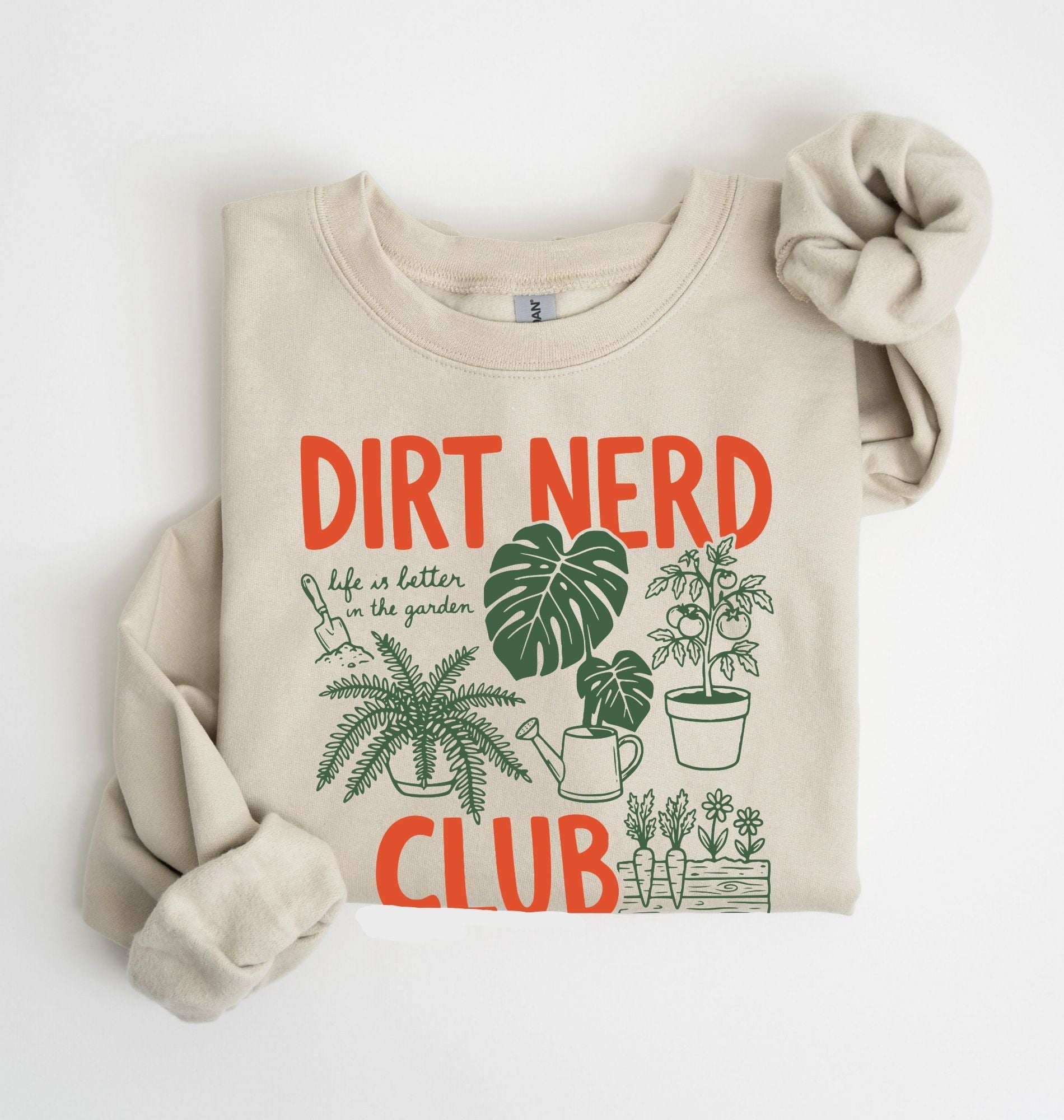 Flat lay of a sand Dirt nerd club sweatshirt with plant illustrations perfect gift for gardeners plant lovers and nature enthusiasts on a white background