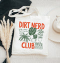 Tote bag with 'Dirt Nerd Club' text and plant illustrations on a textured surface.