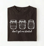 Flat lay of a dark chocolate Funny sourdough shirt with starter jars illustration perfect gift for bakers and fermentation lovers on a white background 