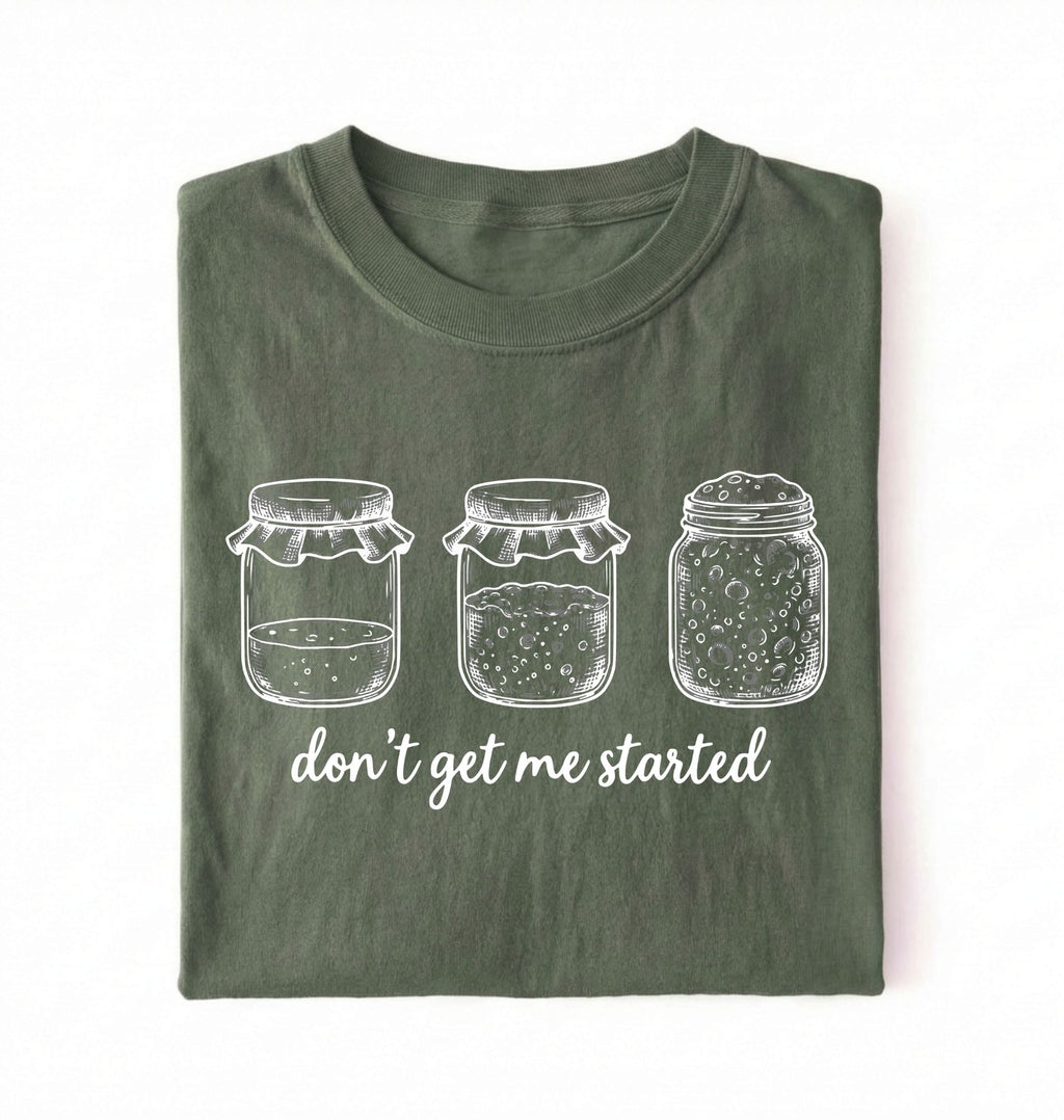 Flat lay of a moss Funny sourdough shirt with starter jars illustration perfect gift for bakers and fermentation lovers on a white background