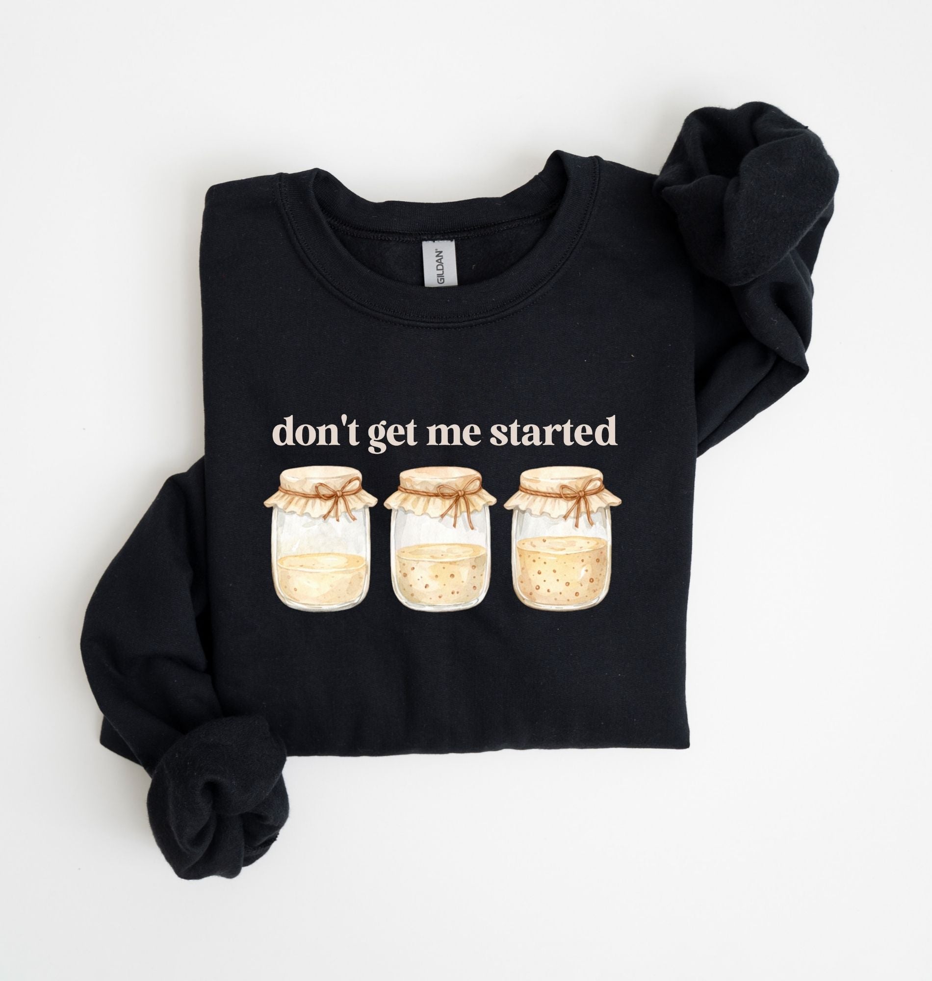 Flat lay of a white Cottagecore kitchen sweatshirt with jars illustration cozy baking lover gift on a white background 