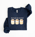 Flat lay of a navy Cottagecore kitchen sweatshirt with jars illustration cozy baking lover gift on a white background 