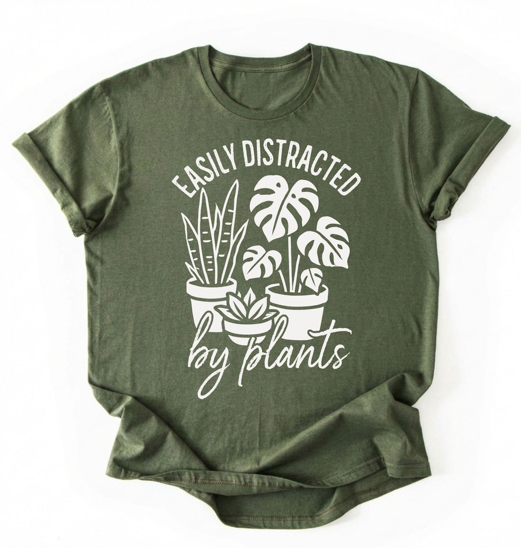 A moss color shirt with a text written "easily distracted by plants" with houseplant illustration plant lover gift on a white background 