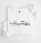 A white long-sleeve sweatshirt laid flat on a white background, featuring a black line art graphic of baking ingredients: a bowl, flour bag, butter stick, sugar jar, vanilla bottle, and eggs.