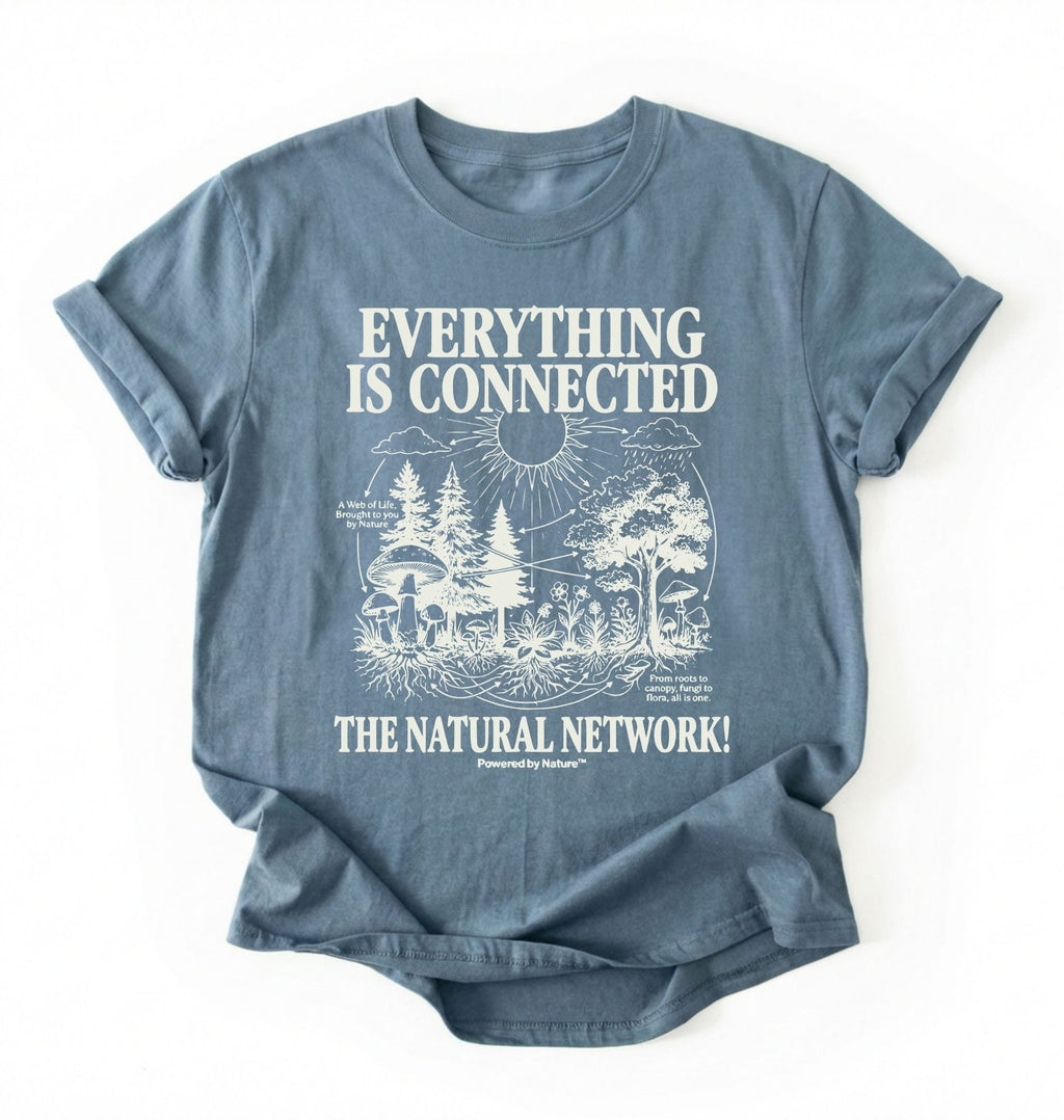 Flat lay of a stone blue t-shirt featuring a forest and fungi illustration with text reading “Everything Is Connected The Natural Network.” perfect gift for nature lovers and eco friendly lifestyle on a white background 