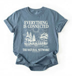 Flat lay of a stone blue t-shirt featuring a forest and fungi illustration with text reading “Everything Is Connected The Natural Network.” perfect gift for nature lovers and eco friendly lifestyle on a white background 