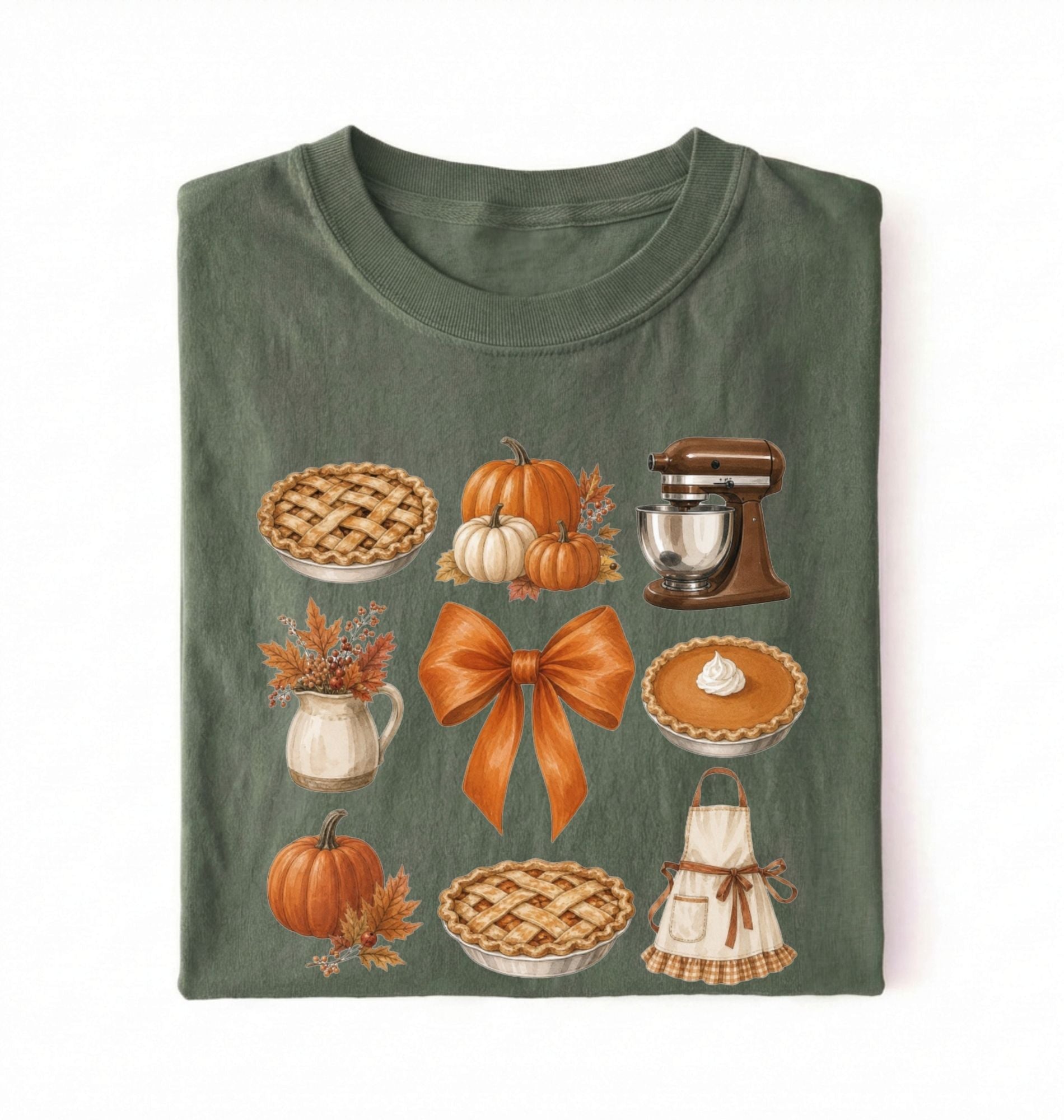 A folded dark green t-shirt with a detailed autumn-themed graphic print featuring pies, pumpkins, a stand mixer, and a bow on a white background 