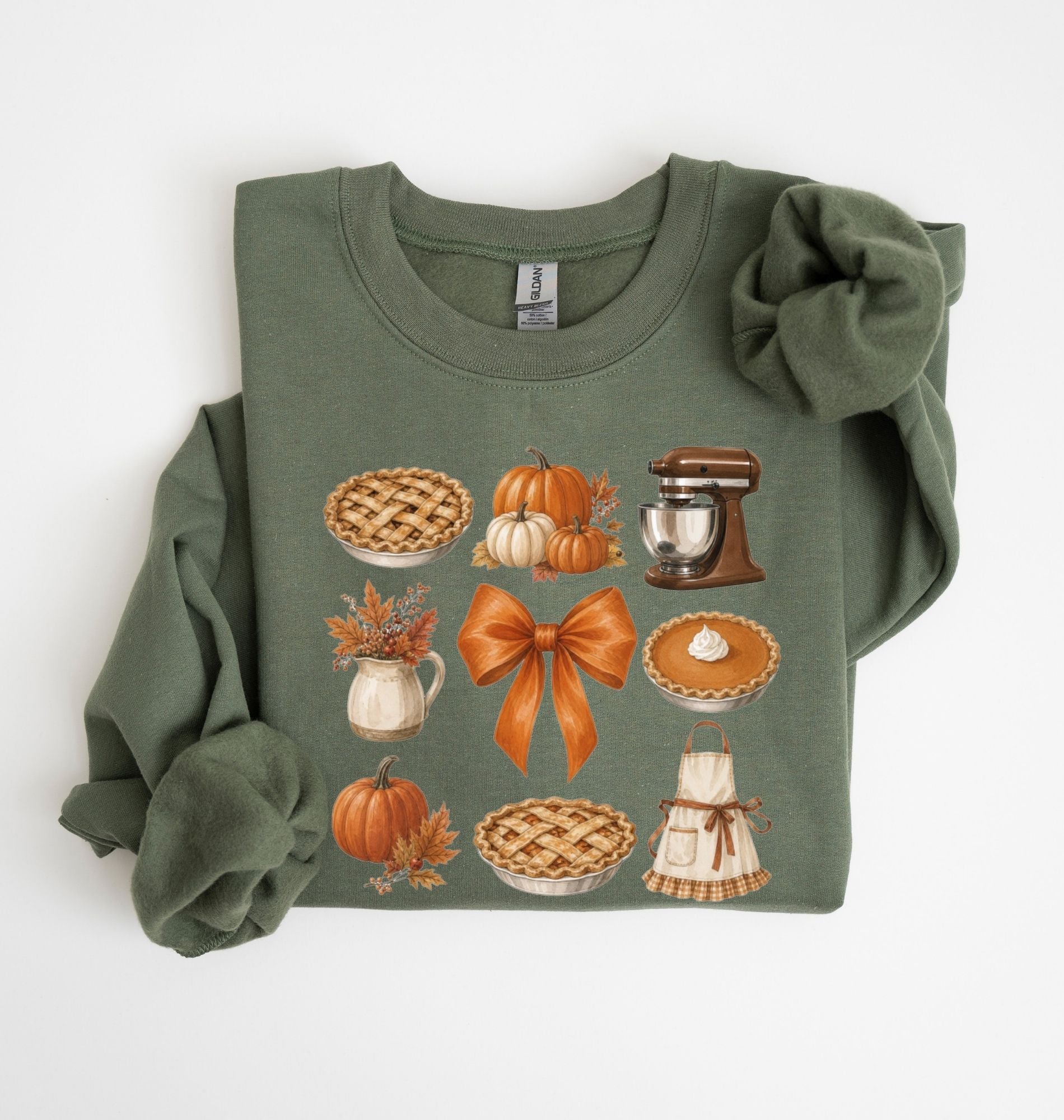 Moss green fall baking sweatshirt featuring pumpkin pies, pumpkins, autumn leaves, a stand mixer, baking apron and orange bow on a white background 