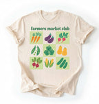 Flat lay of a beige farmers market club shirt white vegetable gardening t shirt cottagecore farmer market gift on a white background 