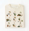 Beige t-shirt with illustrated gardeners wearing duck costumes on a white background