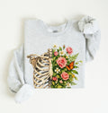Flat lay of an Ash Floral ribcage sweatshirt with botanical flowers and butterfly, artistic skeleton plant lover gift on a white background