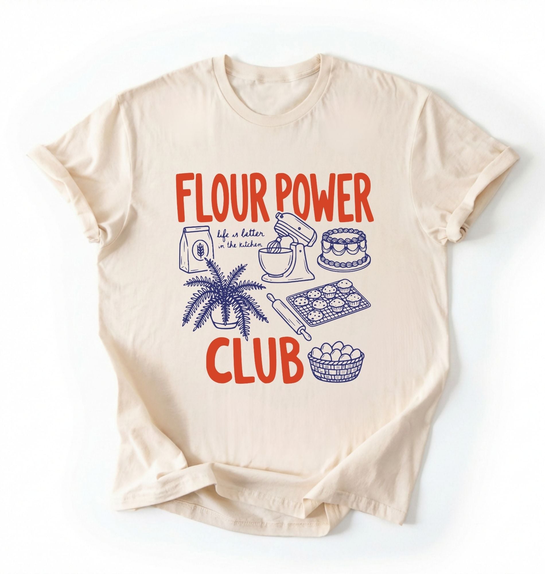 Flat lay of a cream flour power club shirt with stand mixer cake cookies and baking illustrations funny baker gift on a white background 