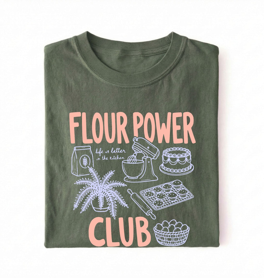 Flat lay of a green flour power club shirt with stand mixer cake cookies and baking illustrations funny baker gift on a white background 