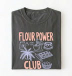Flat lay of a pepper flour power club shirt with stand mixer cake cookies and baking illustrations funny baker gift on a white background 