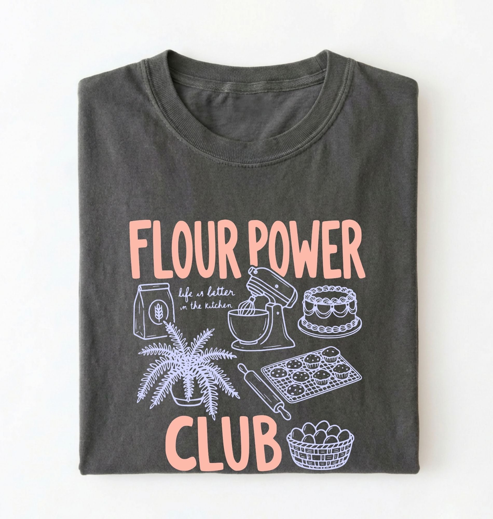 Flat lay of a pepper flour power club shirt with stand mixer cake cookies and baking illustrations funny baker gift on a white background 