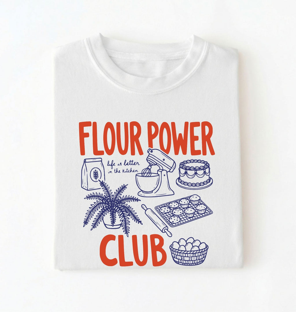 Flat lay of a white flour power club shirt with stand mixer cake cookies and baking illustrations funny baker gift on a white background 