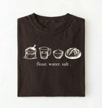 Flat lay of a brown flour water salt shirt cream minimalist baking t shirt bread lover gift sourdough aesthetic design on a white background 