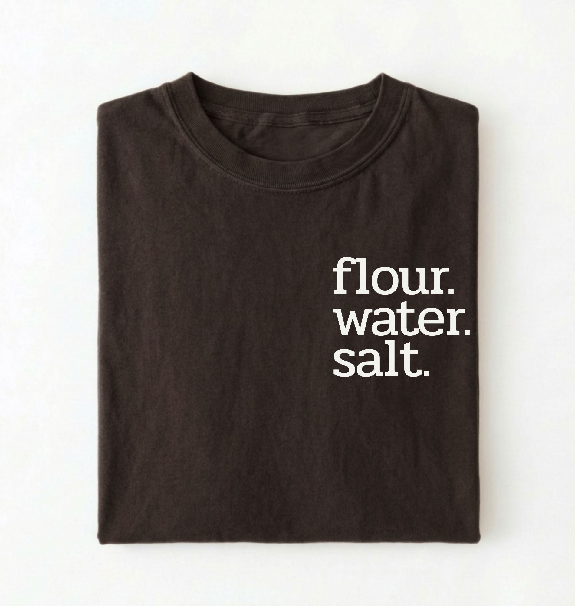 Flat lay of a brown flour water salt shirt black minimalist sourdough baking t shirt bread lover gift simple design on a white background 