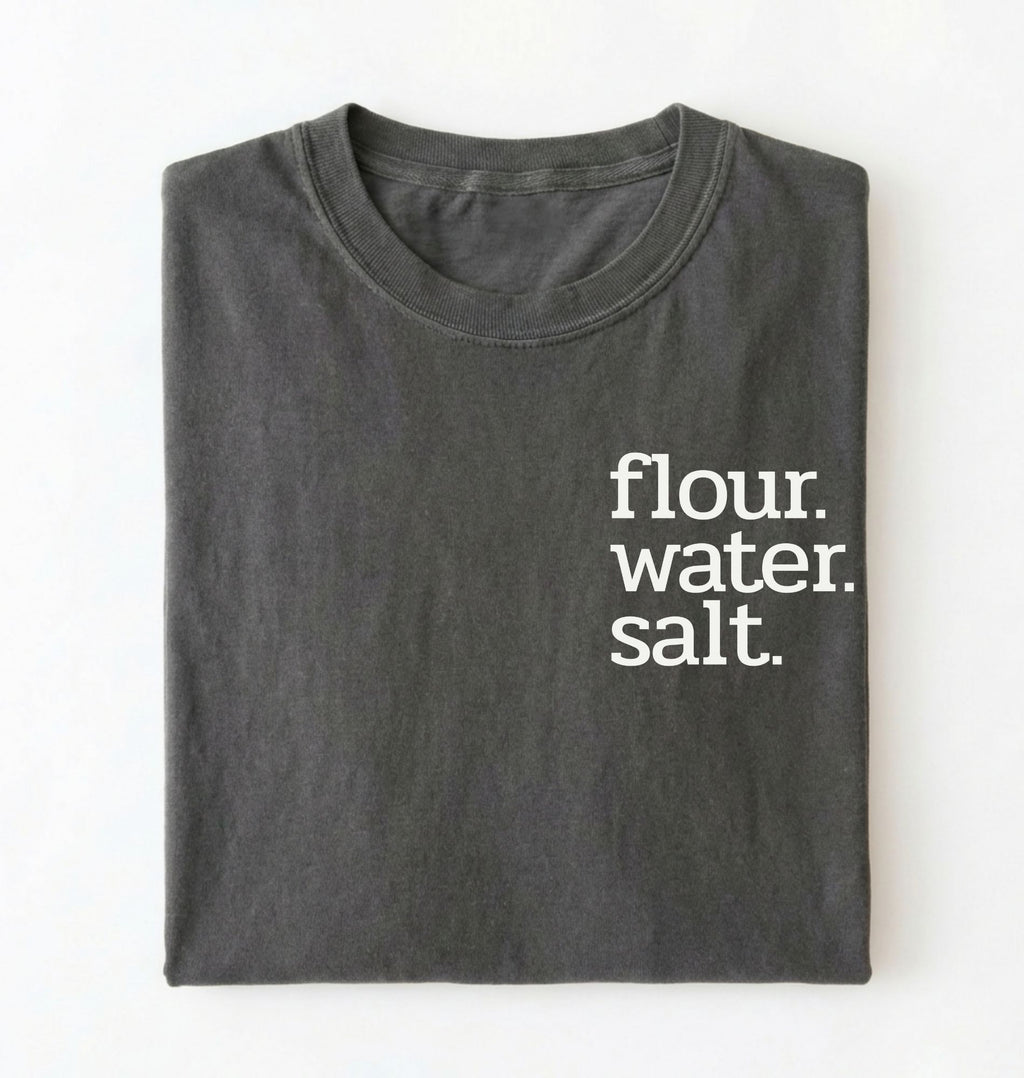 Flat lay of a pepper flour water salt shirt black minimalist sourdough baking t shirt bread lover gift simple design on a white background 