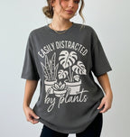 Person wearing a gray t-shirt with plant-themed design and text.
