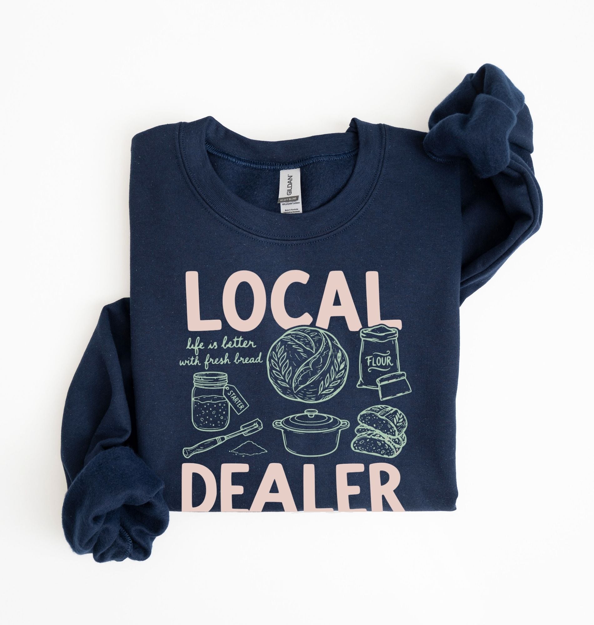 Flat lay of an navy cottagecore baking sweatshirt with Local Dealer text and bread graphics gift for bakers on a white background 