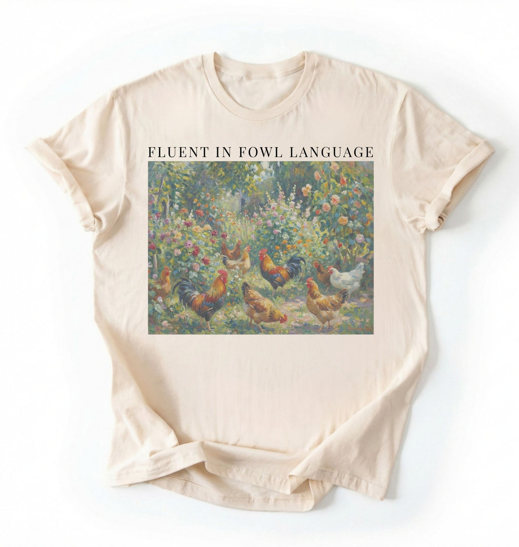 Flat lay of a White Funny Fluent in Fowl Language shirt for chicken lovers and farm animal fans on a white background
