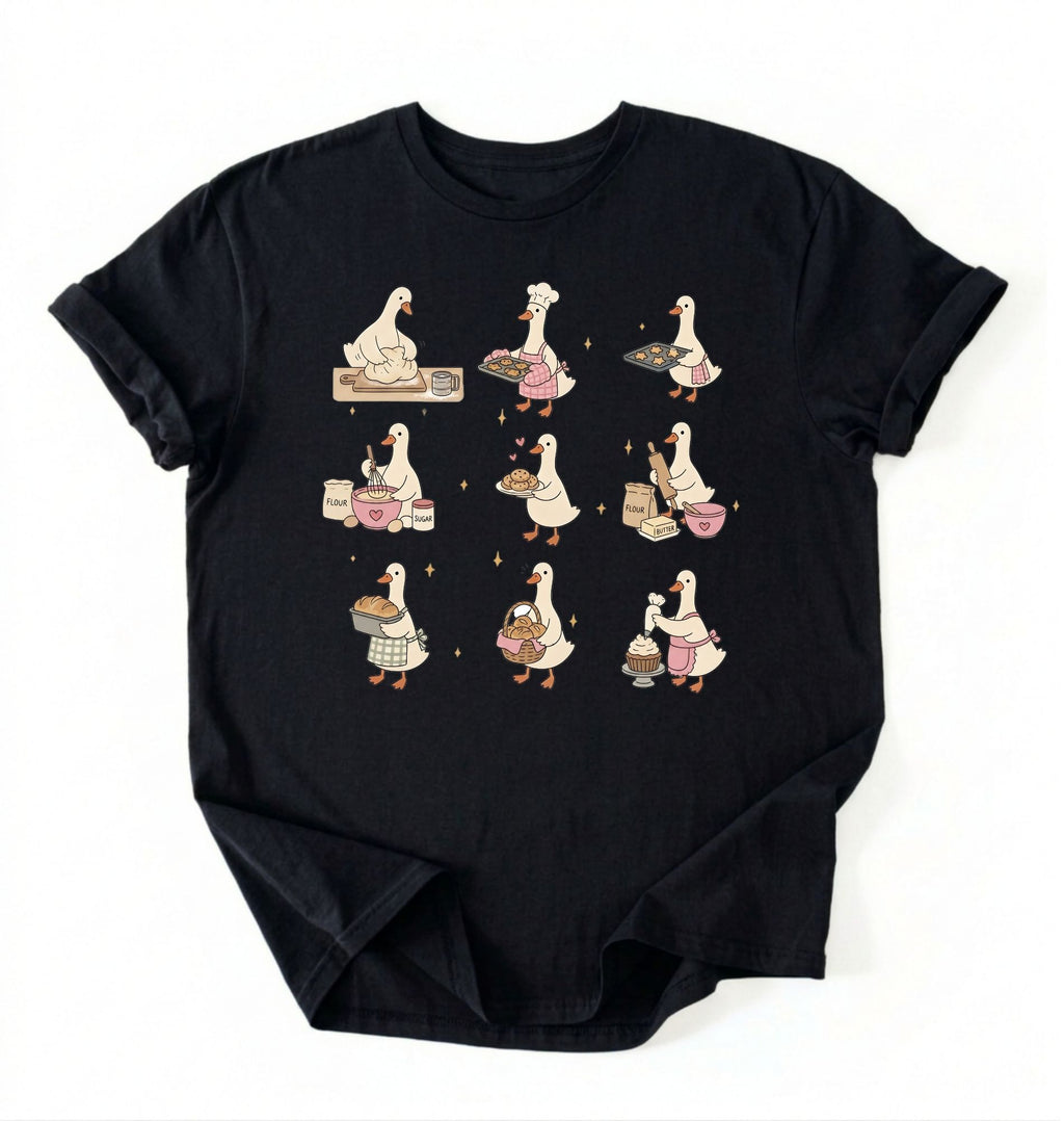Flat lay of a Cute goose baking shirt with cottagecore bread baking illustrations on black tee on a white background 