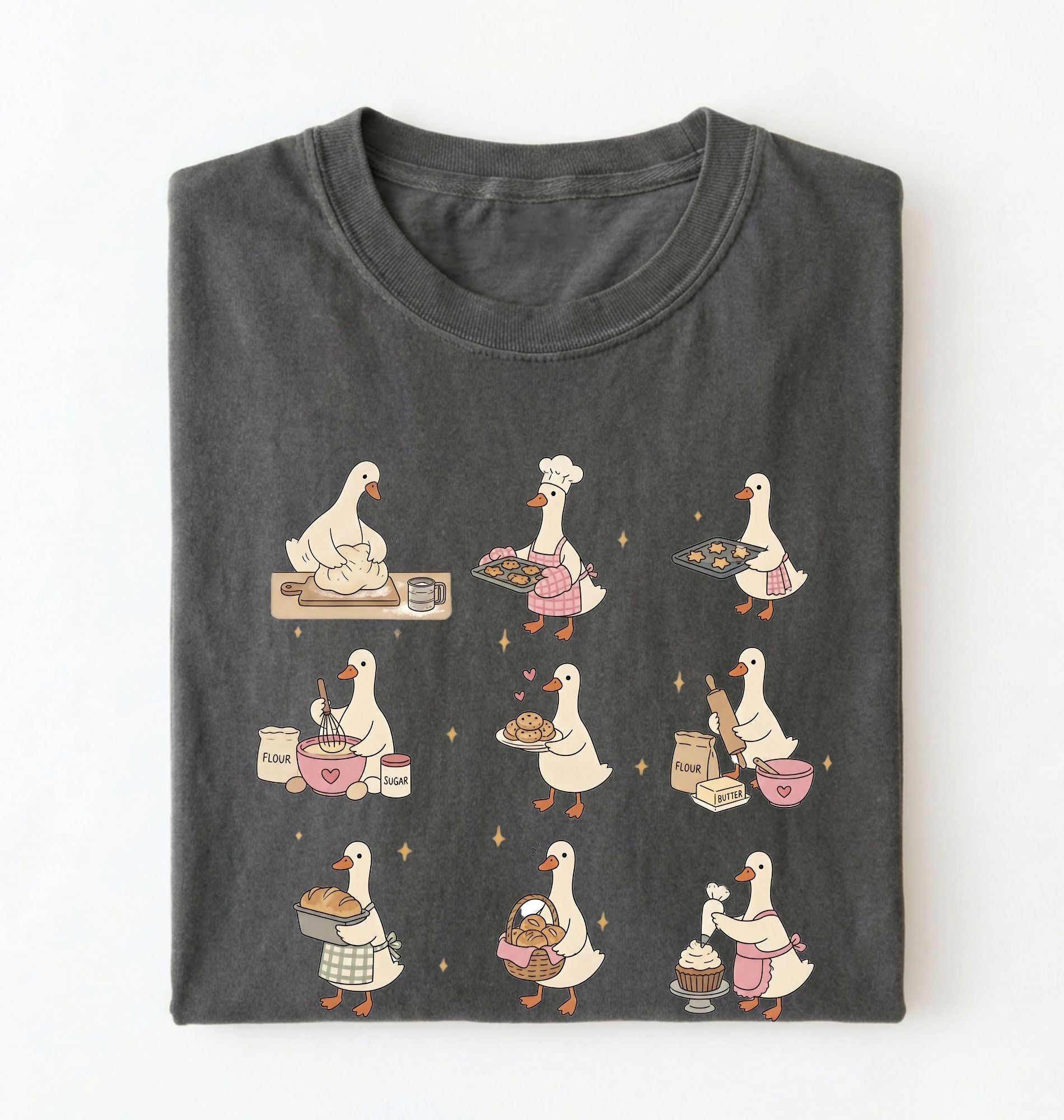 Flat lay of a Cute goose baking shirt with cottagecore bread baking illustrations on pepper tee on a white background 