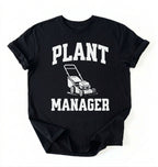 Flat lay of a black Gardening dad shirt featuring bold varsity style Plant Manager text on a white background 
