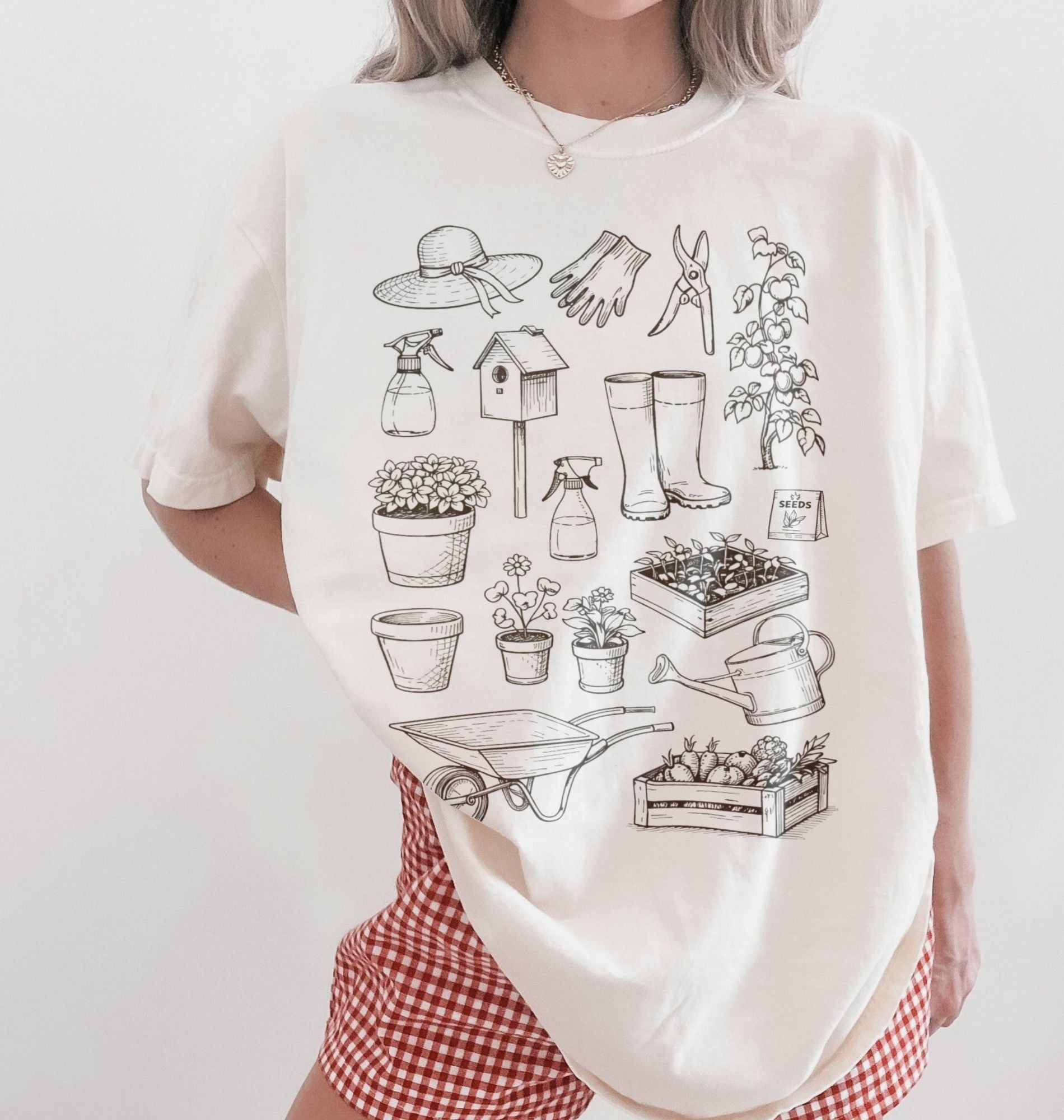 Person wearing a white t-shirt with gardening illustrations on a plain background