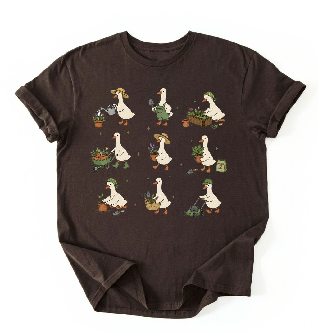Flat lay of a gardening goose shirt brown cute goose t shirt cottagecore gardening aesthetic gift on a white background 