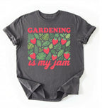 Flat lay of a Charcoal gardening is my jam shirt white funny plant lover t shirt cute strawberry garden gift on a white background 