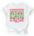Flat lay of a white gardening is my jam shirt white funny plant lover t shirt cute strawberry garden gift on a white background 