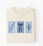 Flat lay of an ivory Cottagecore baking shirt with blue gingham pattern and baking icons perfect gift for bakers and vintage kitchen lovers on a white background 