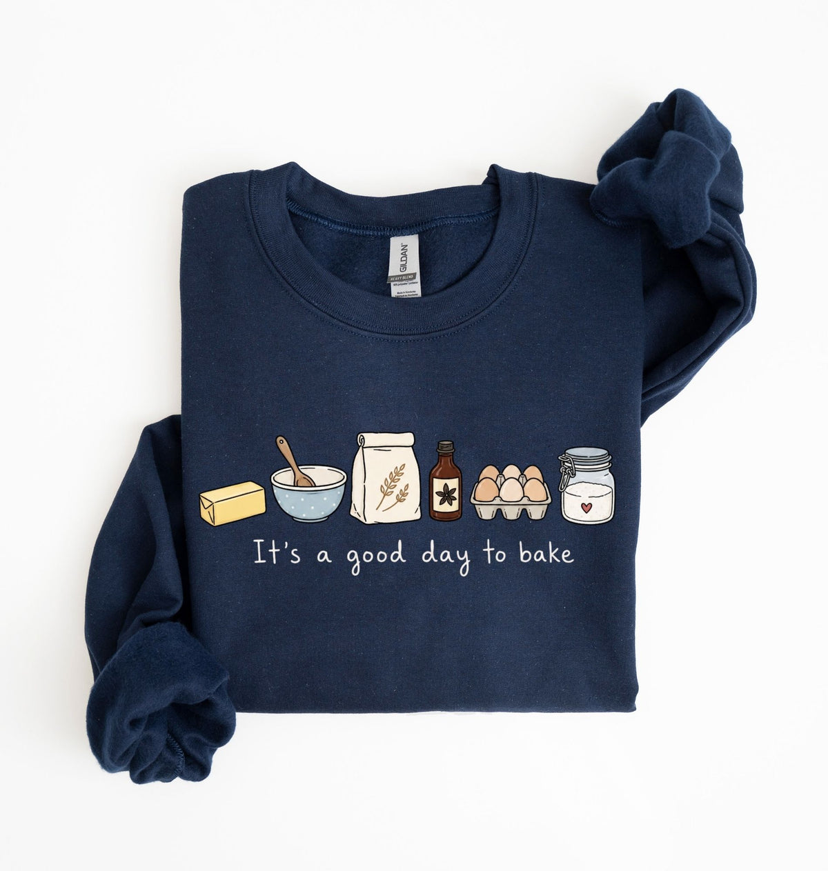 A navy blue long-sleeve sweatshirt with a graphic of baking ingredients and the text 'It's a good day to bake' on the front, displayed flat on a white background.