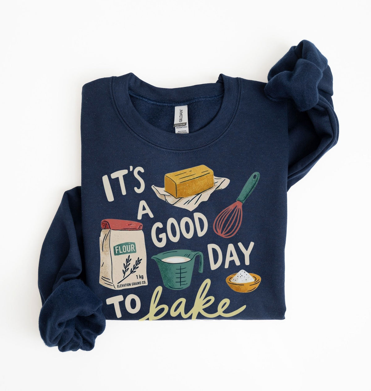 A navy blue long-sleeve sweatshirt with a 'It's a good day to bake' graphic print, styled flat on a white background with one sleeve folded over.