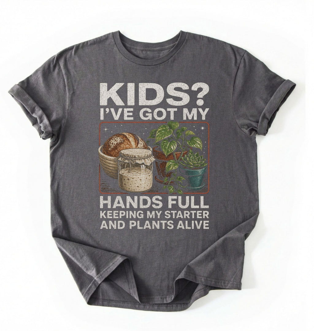 Flat lay of a charcoal hands full sourdough shirt black funny plant lover baking t shirt starter and plants gift on a white background 