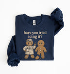 A navy blue long-sleeve sweatshirt with a graphic print of two gingerbread men and the text 'have you tried icing it?' in beige, laid flat on a white background.