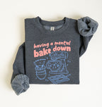 Flat lay of a dark heather Funny Having a Mental Bake Down baking sweatshirt with mixer and baking tools graphic on a white background 
