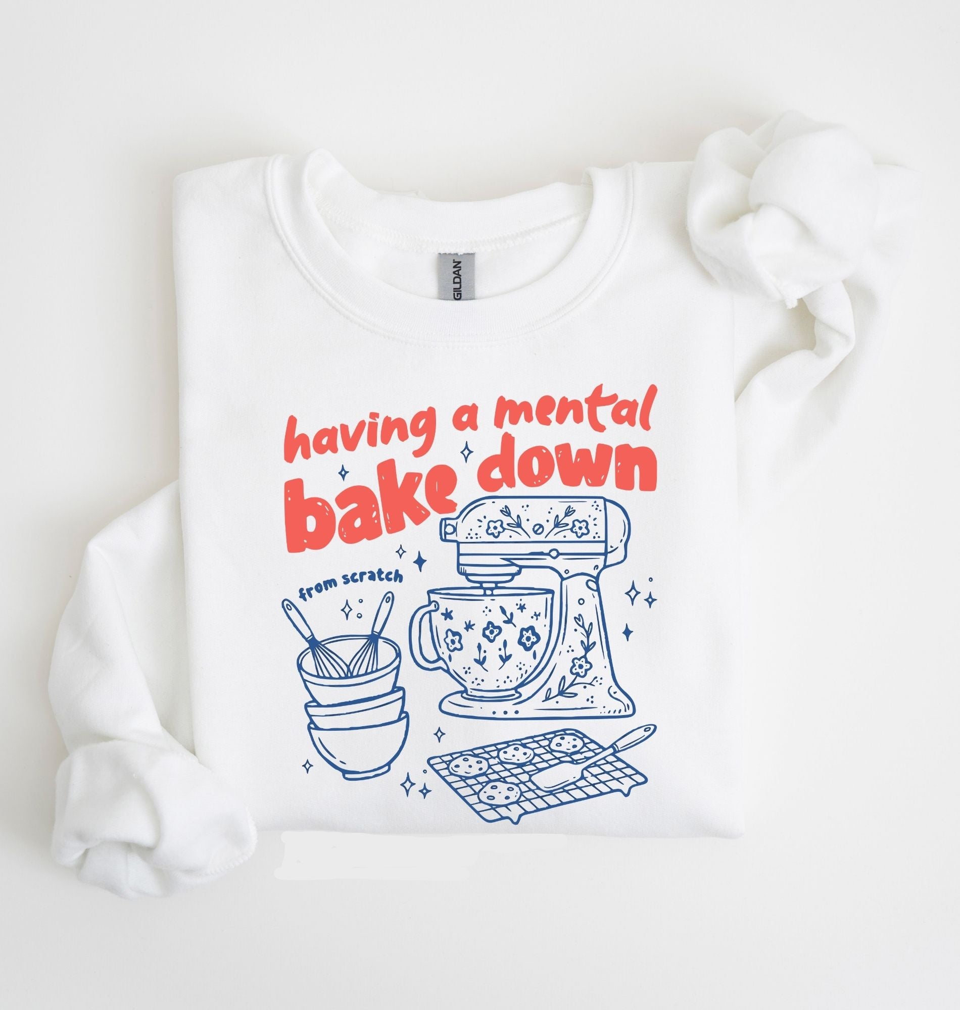 Flat lay of a white Funny Having a Mental Bake Down baking sweatshirt with mixer and baking tools graphic on a white background 
