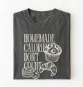 Flat lay of a gray Homemade Calories Don't Count baking shirt with muffin cookie and croissant illustrations on a white background 