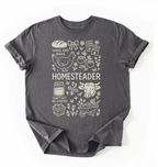 Flat lay of a charcoal homesteader shirt with chicken farm garden and baking icons cottagecore aesthetic gift white t-shirt on a white backgroud