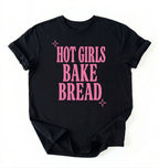 Flat lay of a black hot girls bake bread shirt with pink text funny sourdough baker gift black t-shirt on a white background 